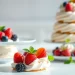 Maak een mousseline dessert met verse bessen op een elegante tafel.