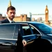 Private chauffeur London welcoming a distinguished passenger by a luxury sedan.